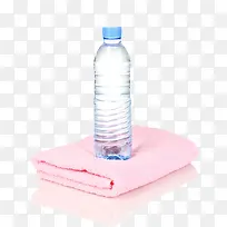 透明解渴在粉红色毛巾上的塑料瓶