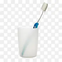 白色塑料杯子里的蓝色牙刷实物