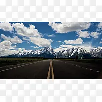 蓝天白云雪山下的高速公路
