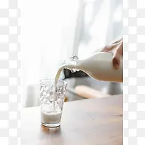 往透明玻璃杯倒牛奶